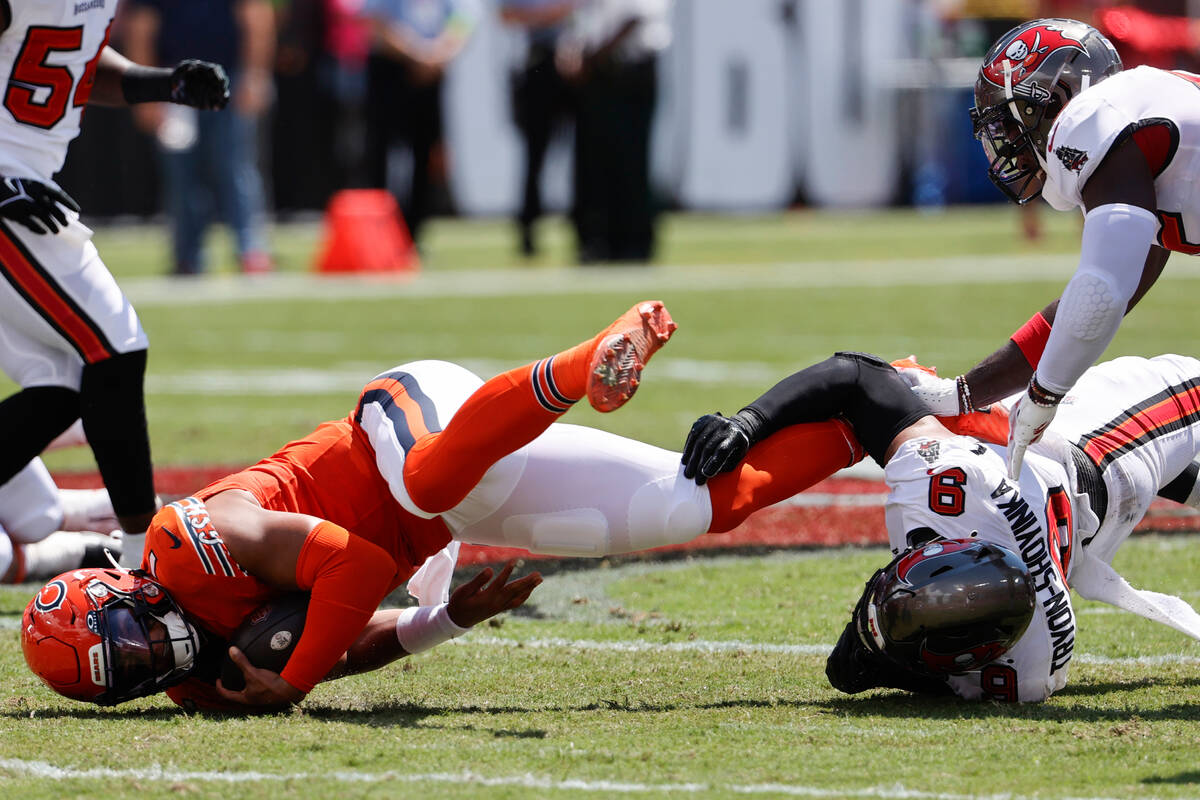 Chicago Bears quarterback Justin Fields is taken down by Tampa Bay Buccaneers linebacker Joe Tr ...