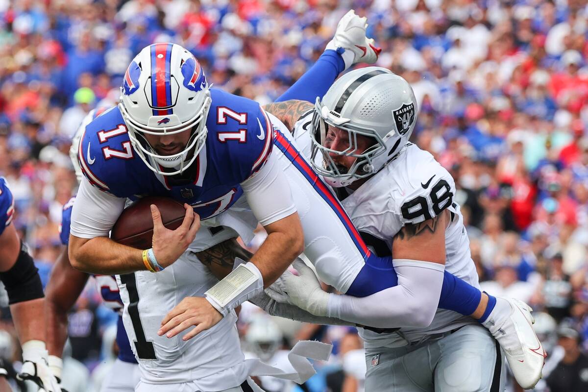 Las Vegas Raiders' Maxx Crosby (98) and Marcus Epps (1) tackle Buffalo Bills quarterback Josh A ...