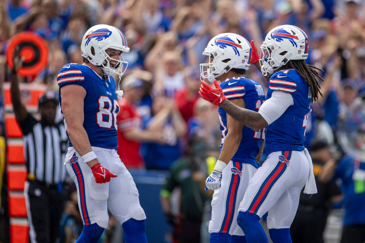 Buffalo Bills tight end Dawson Knox (88) and running back James Cook (4) congratulate wide rec ...