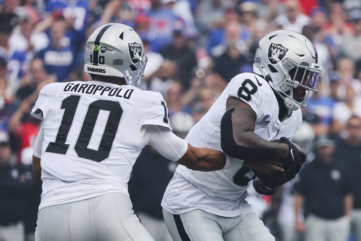 Las Vegas Raiders quarterback Jimmy Garoppolo (10) hands off to Josh Jacobs (8) during the firs ...