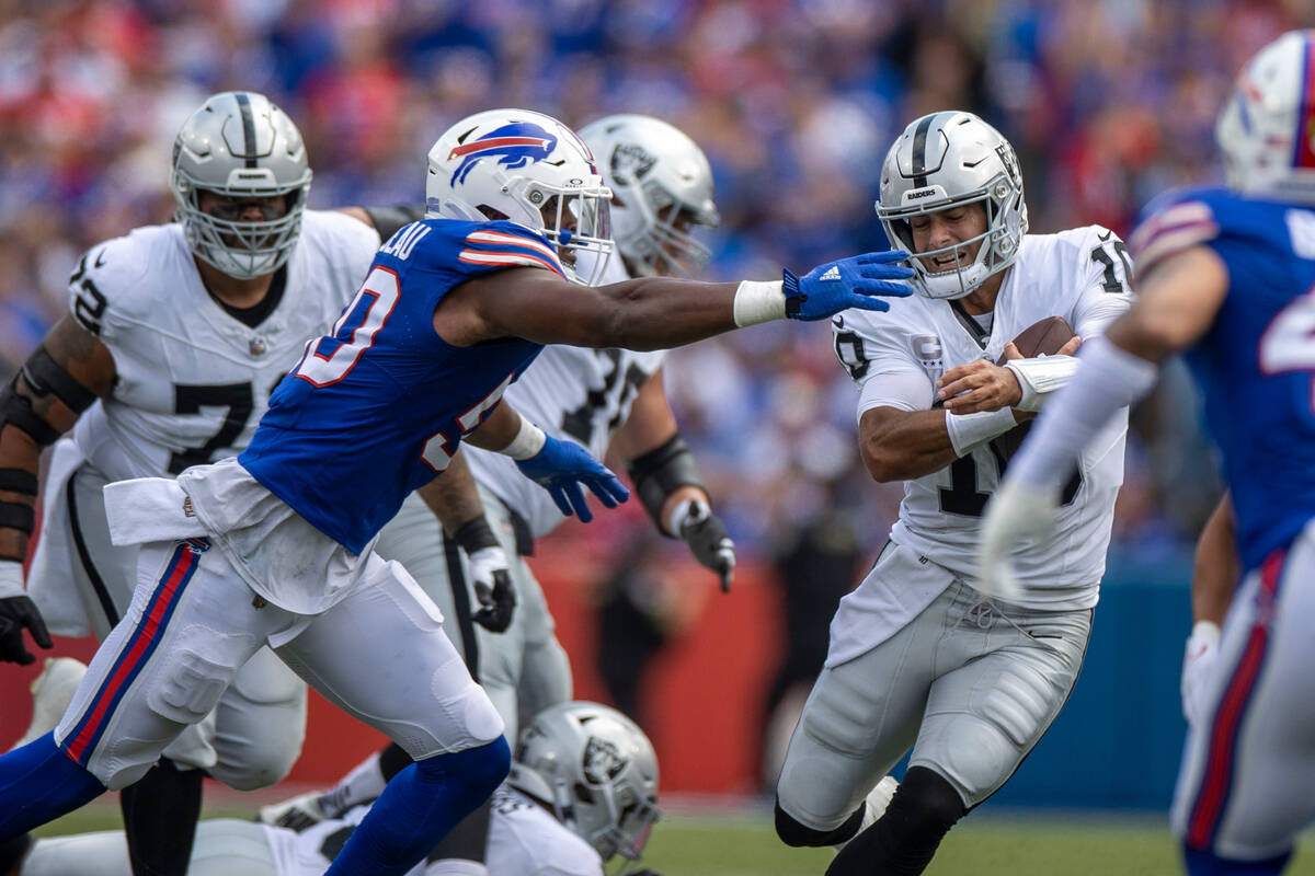 Raiders quarterback Jimmy Garoppolo (10) holds on to the football as Buffalo Bills defensive en ...