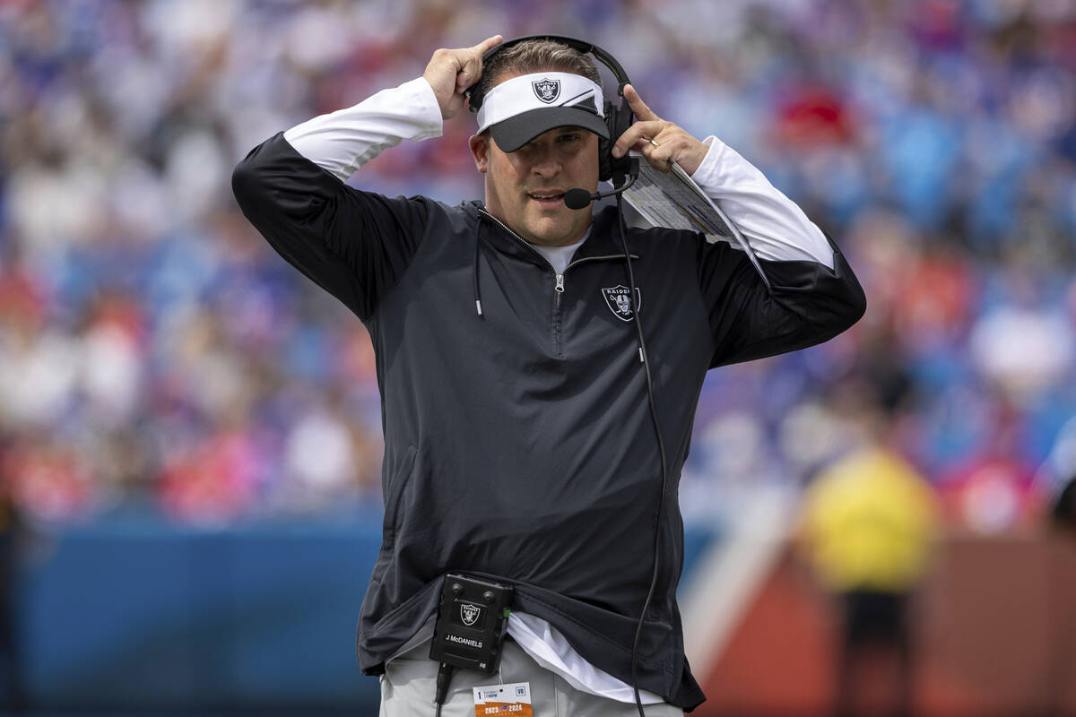 Las Vegas Raiders head coach Josh McDaniels adjusts his headset during an NFL football game, Su ...