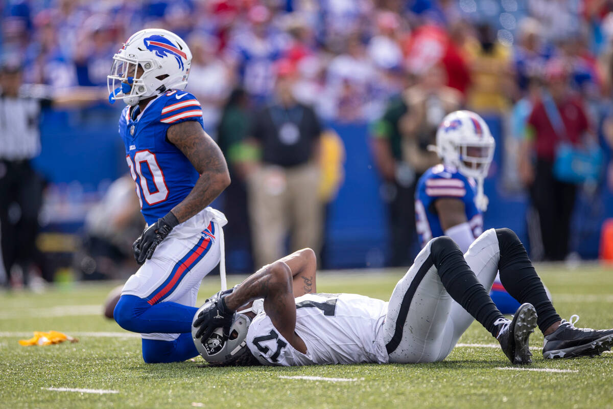 Raiders wide receiver Davante Adams (17) holds his head after taking a hit to the head followin ...