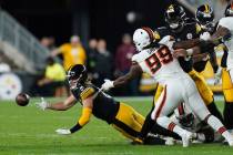Pittsburgh Steelers quarterback Kenny Pickett gets rid of the ball as he falls down during the ...