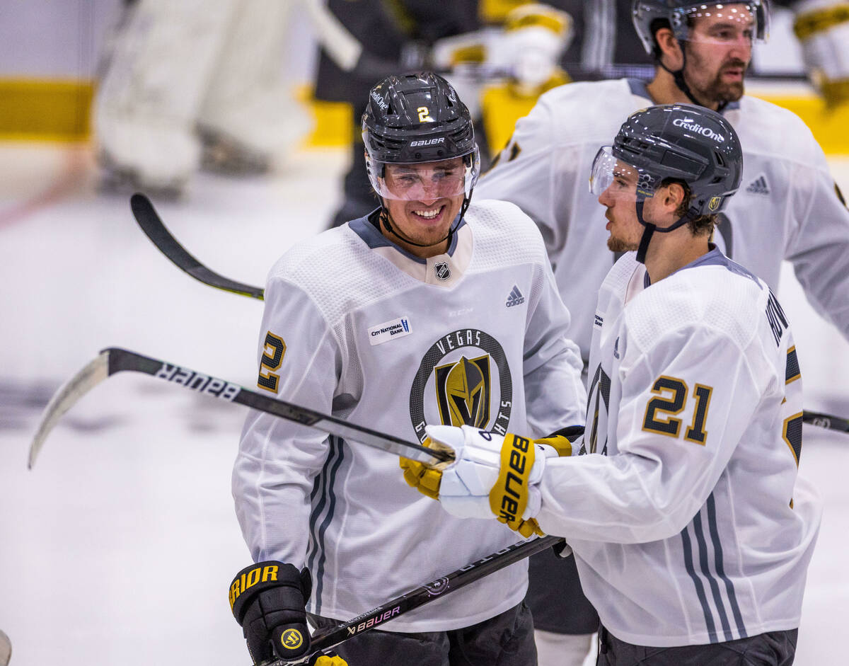 Golden Knights defenseman Zach Whitecloud (2) laughs while talking with center Brett Howden (21 ...