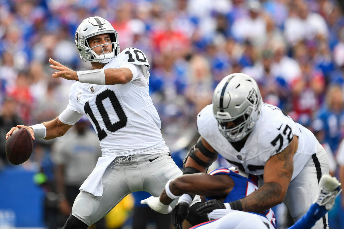 Las Vegas Raiders quarterback Jimmy Garoppolo (10) throws a pass as guard Jermaine Eluemunor (7 ...