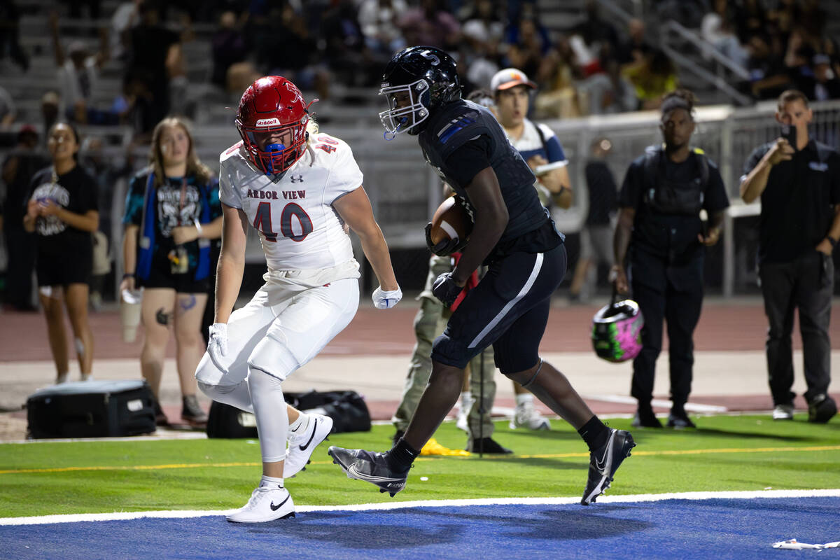 Desert Pines running back Greg Burrell (5) scores a touchdown while Arbor View outside lineback ...