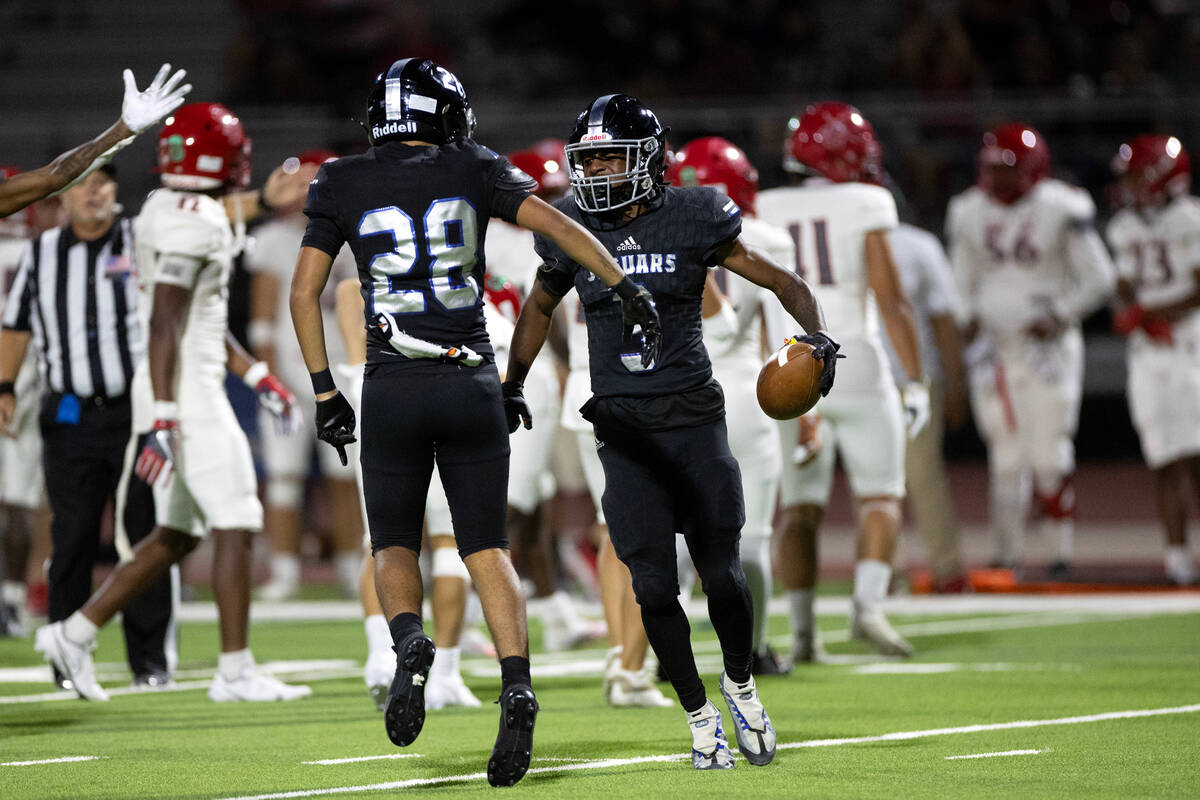 Desert Pines wide receiver Niqel Junor (3) celebrates with Desert Pines strong safety Eddie Loe ...