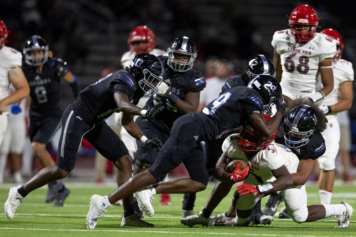 Desert Pines outside linebacker Elisah Banks (29) and linebacker Isaiah Teo (14) tackle Arbor V ...