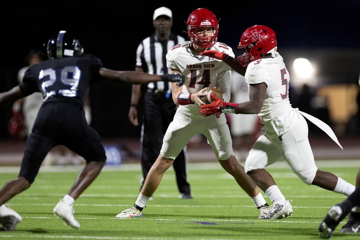 Arbor View quarterback Alonzo Balderrama (14) hands the ball off to running back Makhai Donalds ...