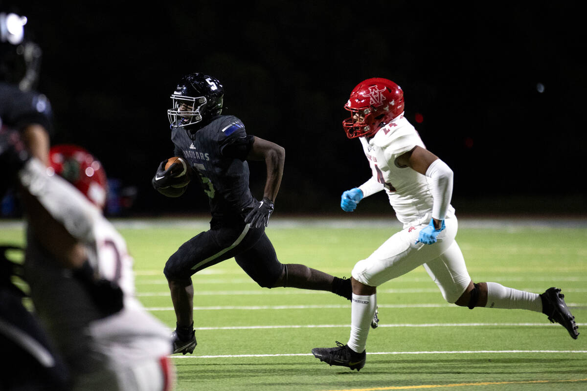 Desert Pines running back Greg Burrell (5) runs the before before scoring a touchdown while Arb ...