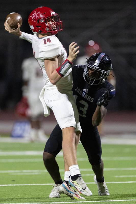 Arbor View quarterback Alonzo Balderrama (14) passes while Desert Pines linebacker Semauri Norr ...