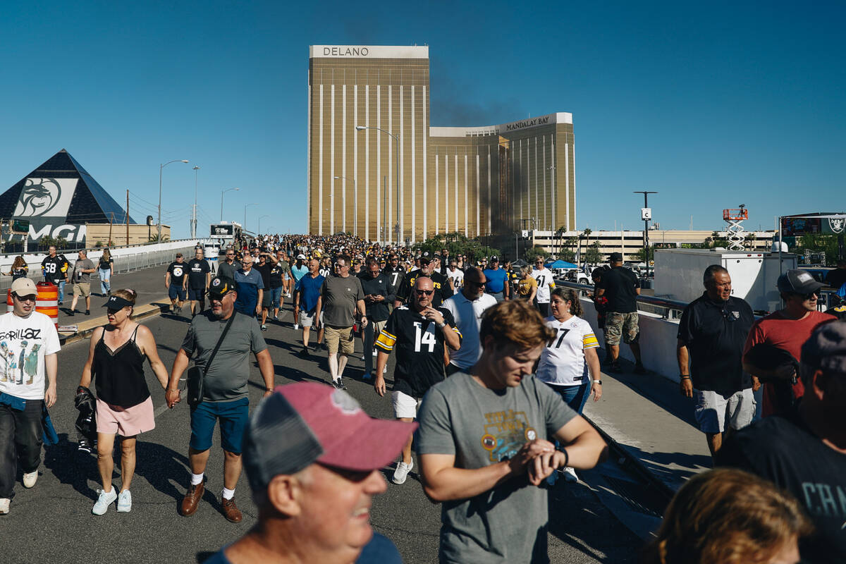 Fans walk across Mandalay Bay Road to get to the Raiders game at Allegiant Stadium on Sunday, S ...