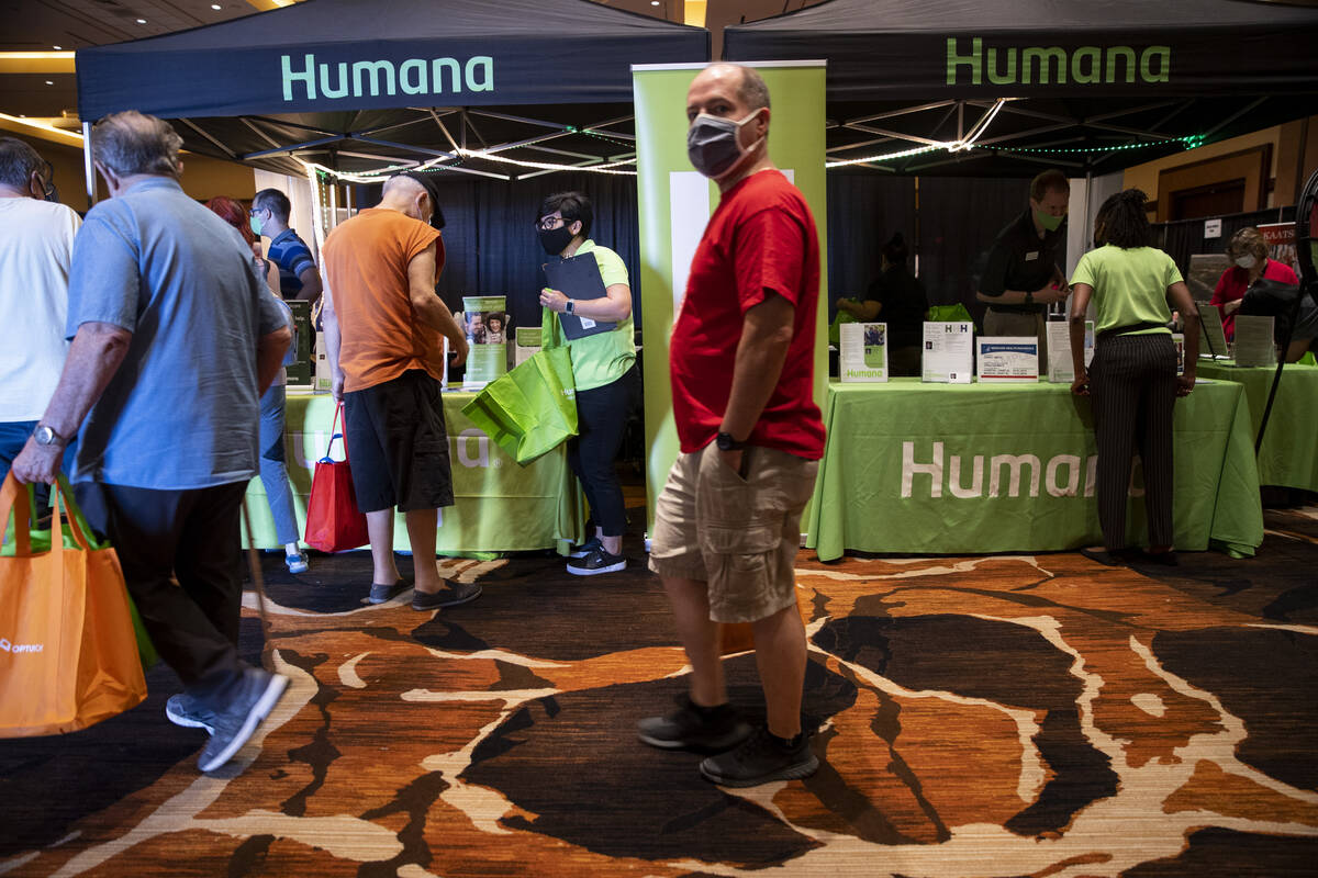 People visit the Humana booth during the Aging Wellness Expo at Red Rock Resort in Las Vegas, S ...