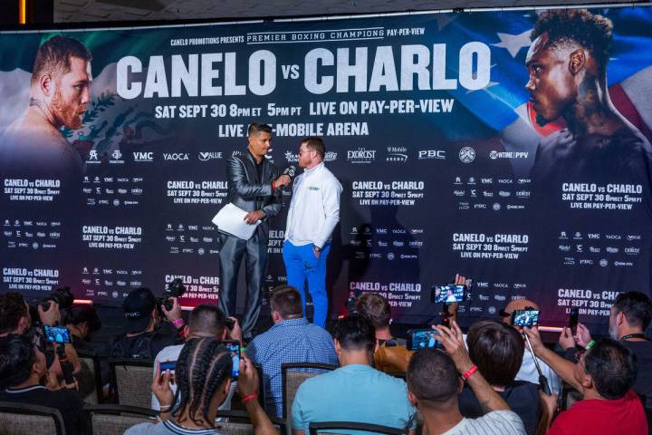 Fight commentator Miguel Flores, left, interviews boxer Canelo Alvarez on stage during fighter ...