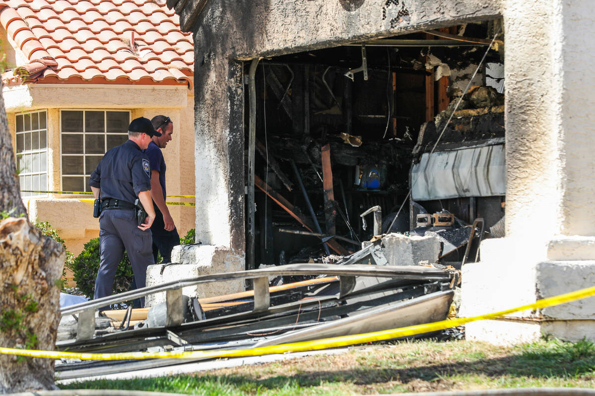 Henderson police and firefighters investigate the perimeters of a demolished home in the afterm ...