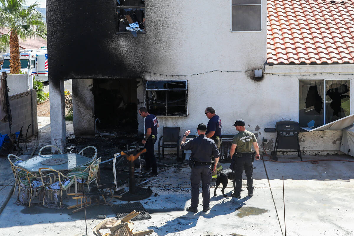 Henderson police and firefighters investigate around a home demolished by a fire, which killed ...