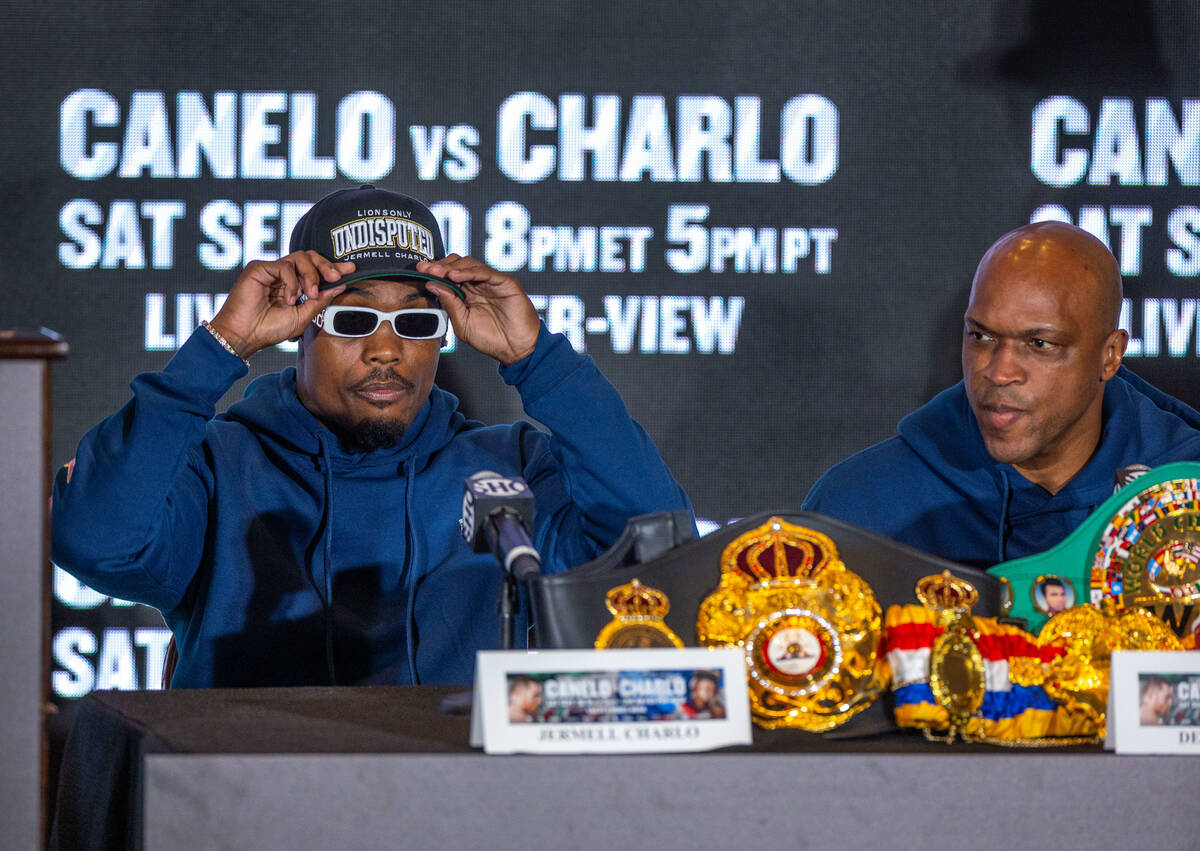 Boxer Jermell Charlo considers an answer while joined by trainer Derrick James during a final p ...