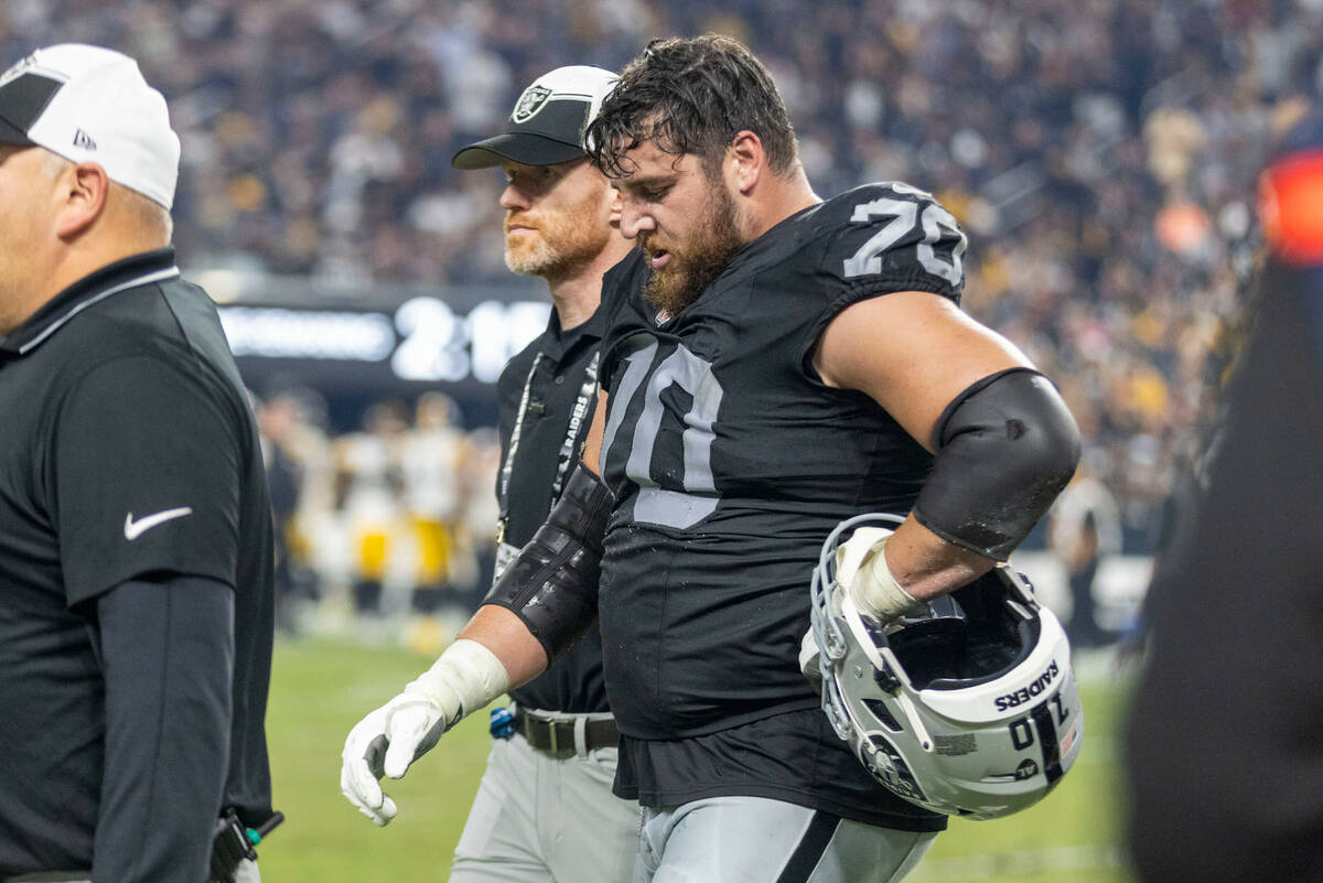 Raiders guard Greg Van Roten (70) comes off the field with trainers during the second half an N ...