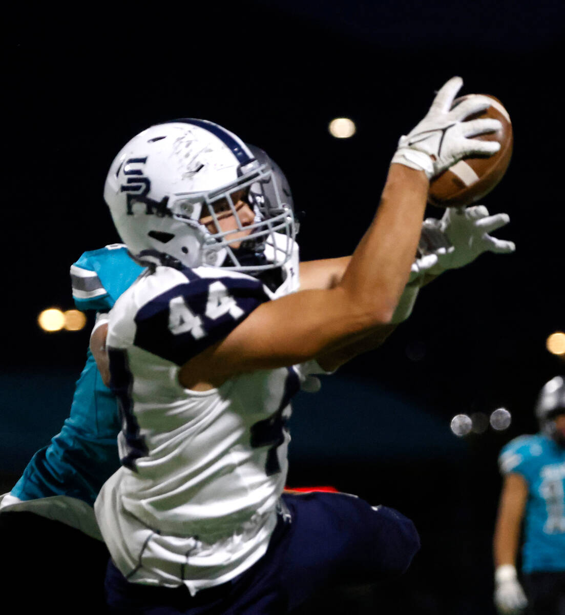 Shadow Ridge High Aaron Coverdell (44) catches a pass as Silverado High Tristan Hudson (1) defe ...