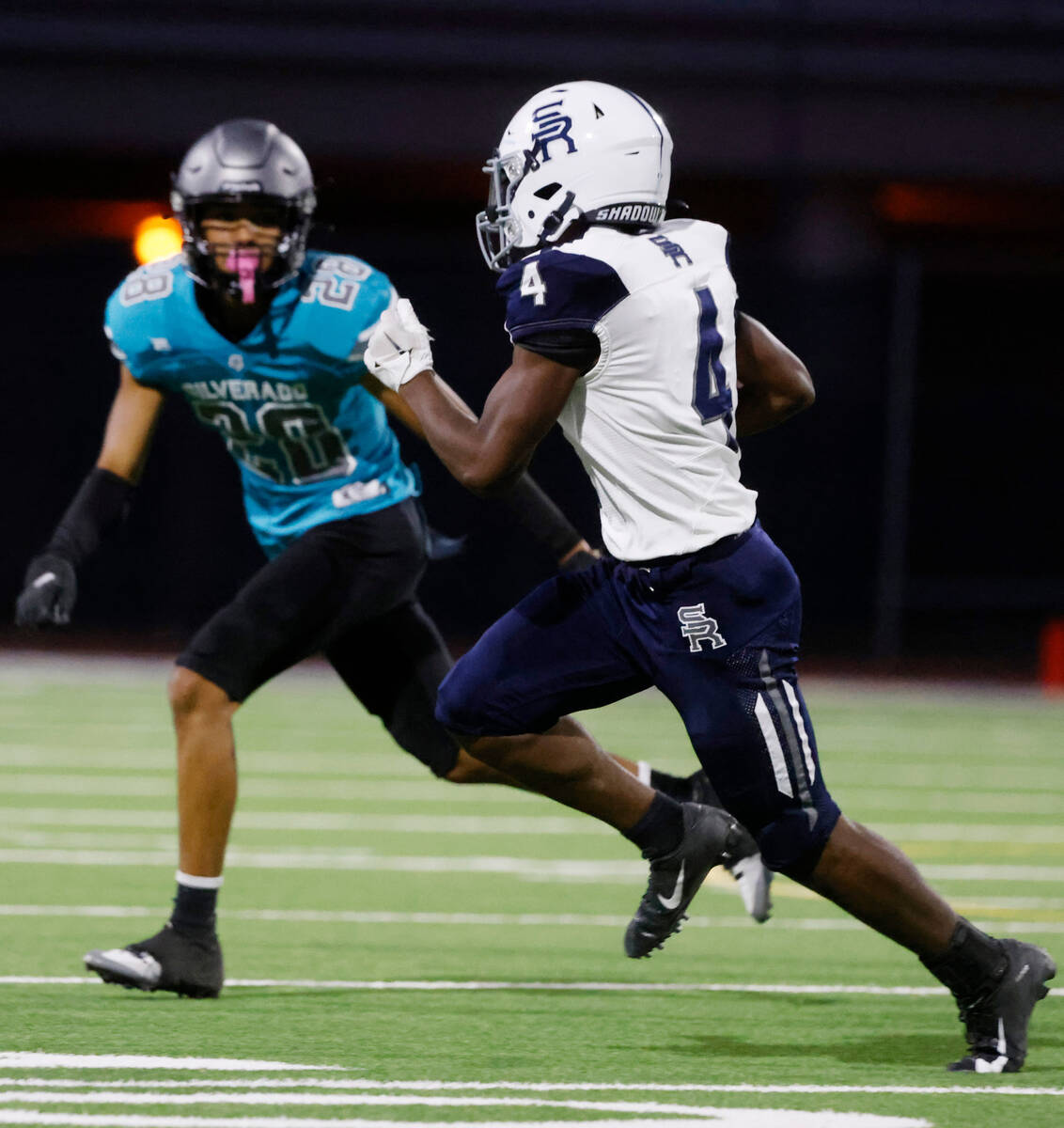 Shadow Ridge High Alec Francisco (4) runs with the ball as Silverado High Ian-Jmes Ioane (28) d ...