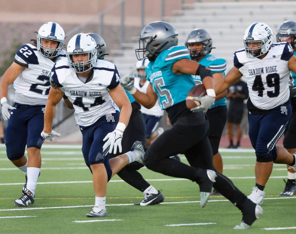 Silverado High Kaina Crisostomo (15) is surrounded by Shadow Ridge High defense as he runs with ...