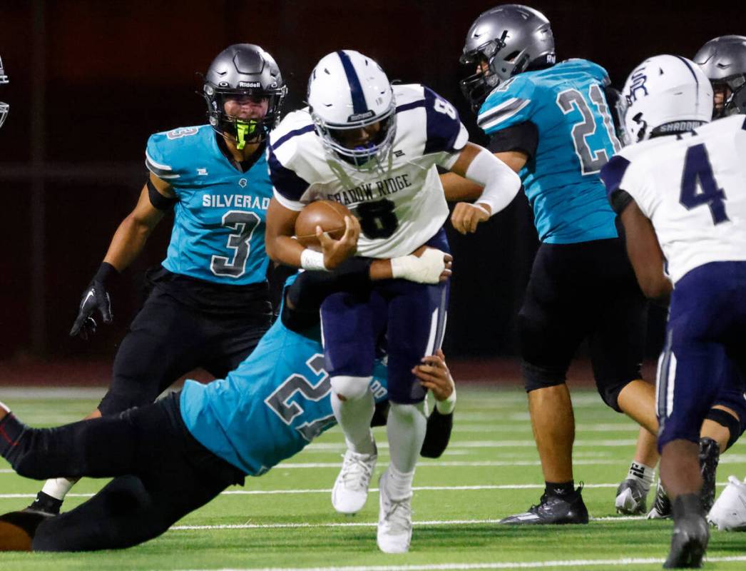 Shadow Ridge High quarterback Coen Coloma (8) avoids a tackle from Silverado High Tau Epenisa ( ...