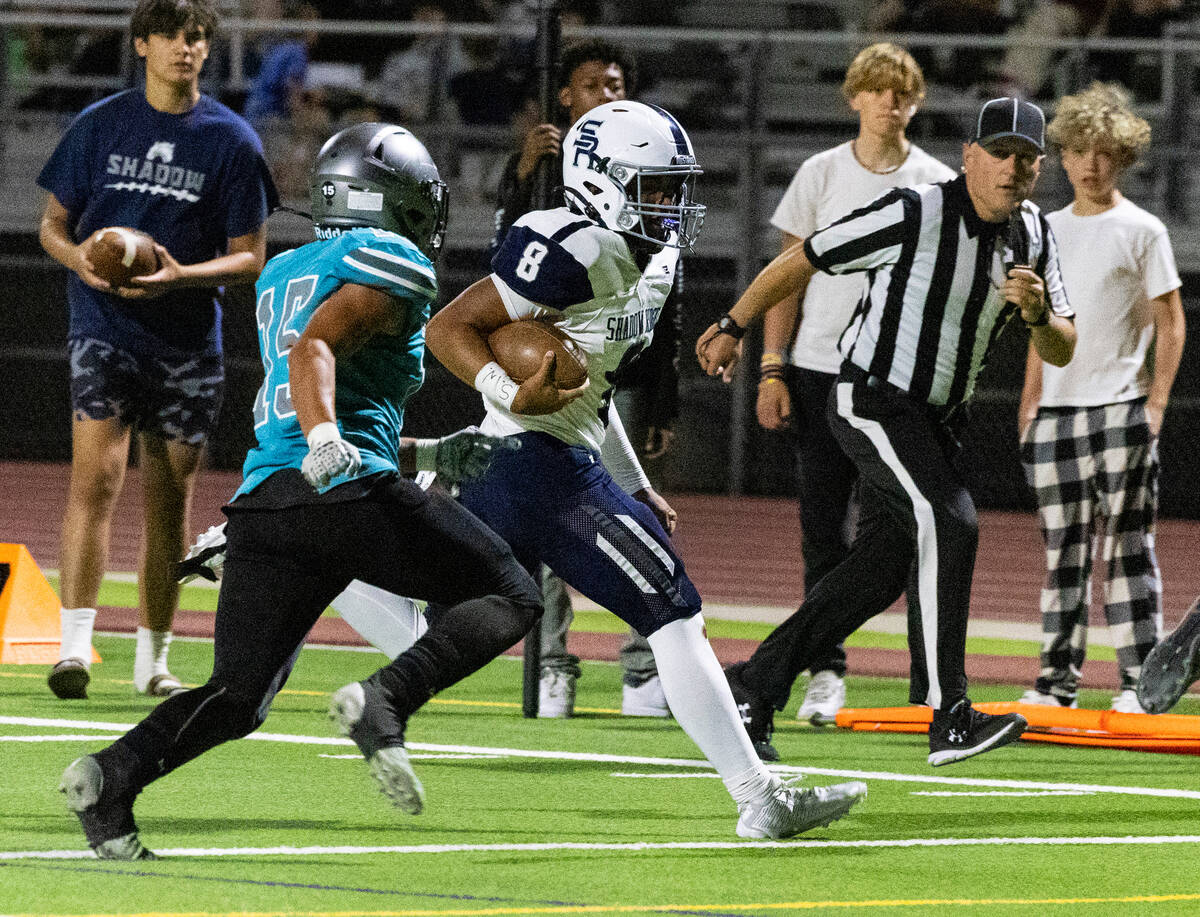 Shadow Ridge High quarterback Coen Coloma (8) chased by Silverado High Kaina Crisostomo (15) du ...