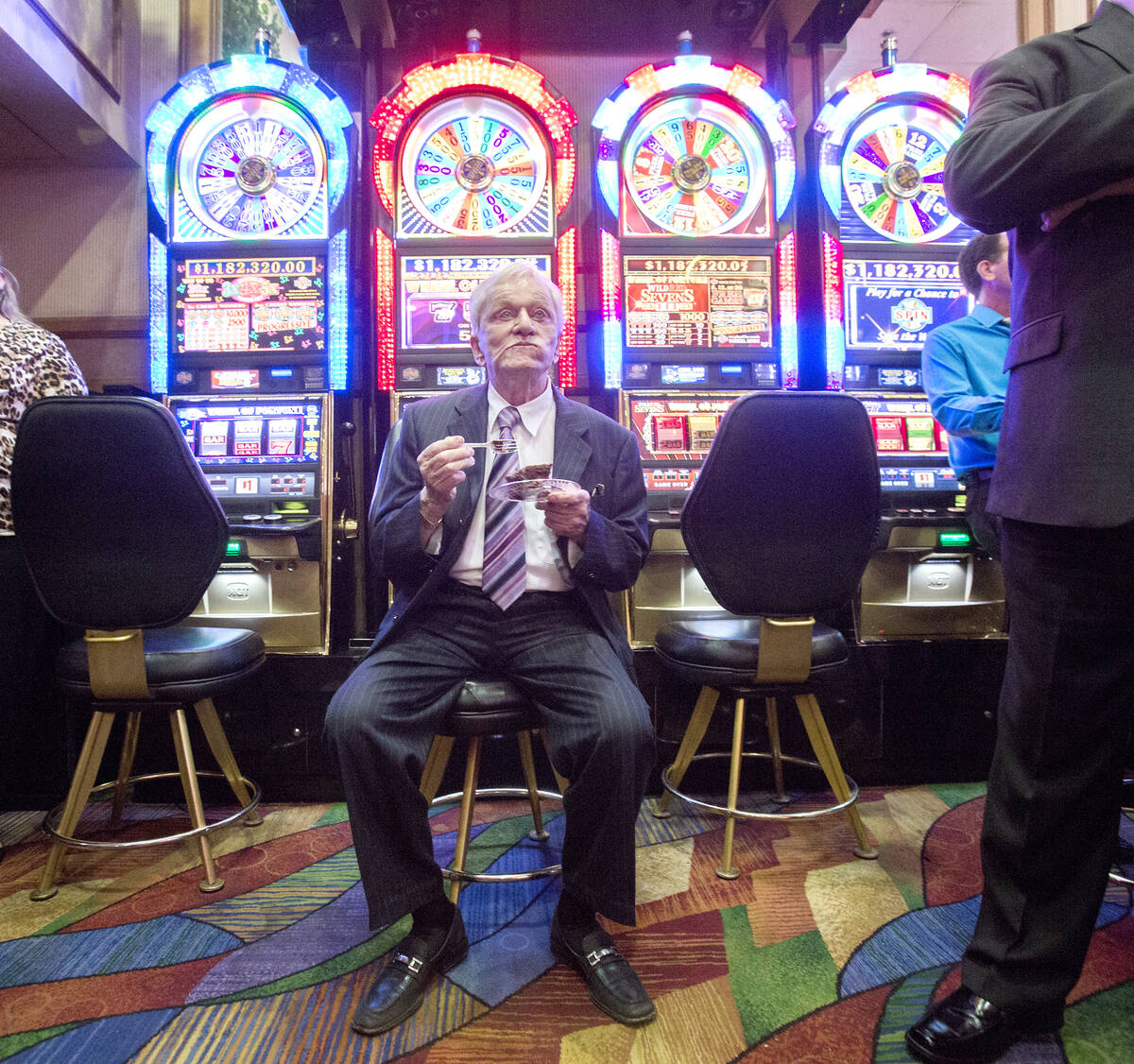 Don Laughlin, owner of the Riverside Resort, eats a piece of chocolate cake near a bank of slot ...