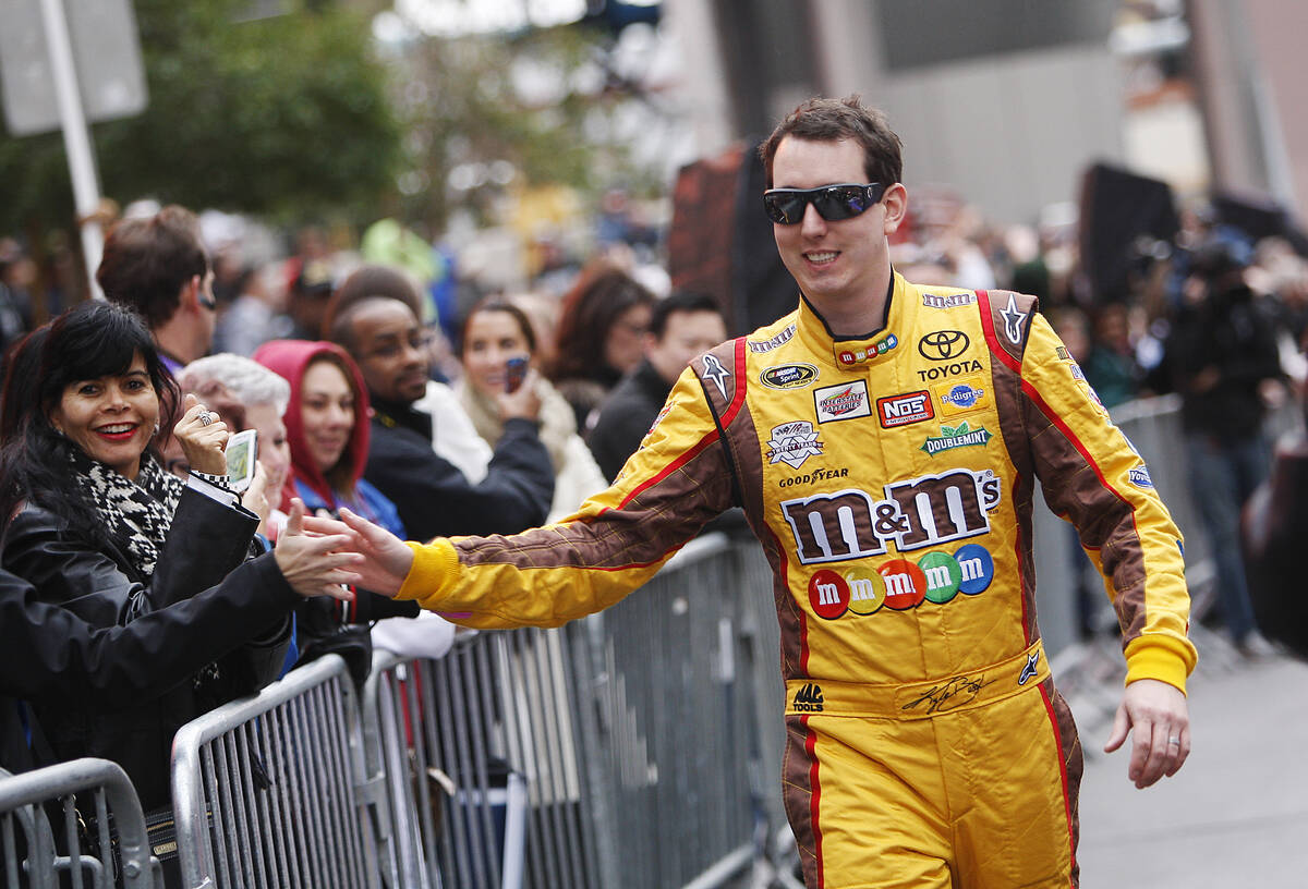 Driver Kyle Busch greets his fans during NASCAR Champion's Week Victory Lap on the Las Vegas St ...