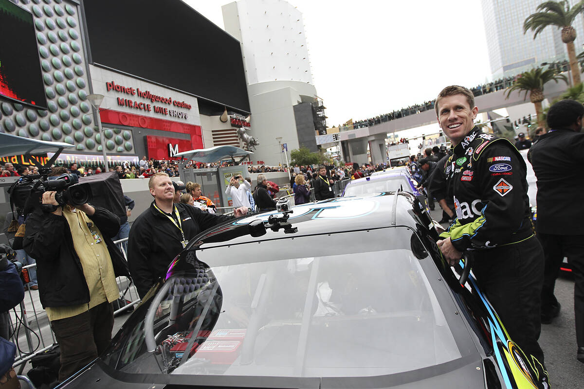Driver Carl Edwards climbs into his car during NASCAR Champion's Week Victory Lap on the Las Ve ...