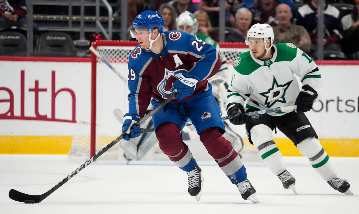 Colorado Avalanche center Nathan MacKinnon, left, looks to pass the puck as Dallas Stars right ...