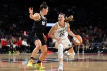 New York Liberty guard Sabrina Ionescu (20) dribbles around Las Vegas Aces guard Kelsey Plum (1 ...