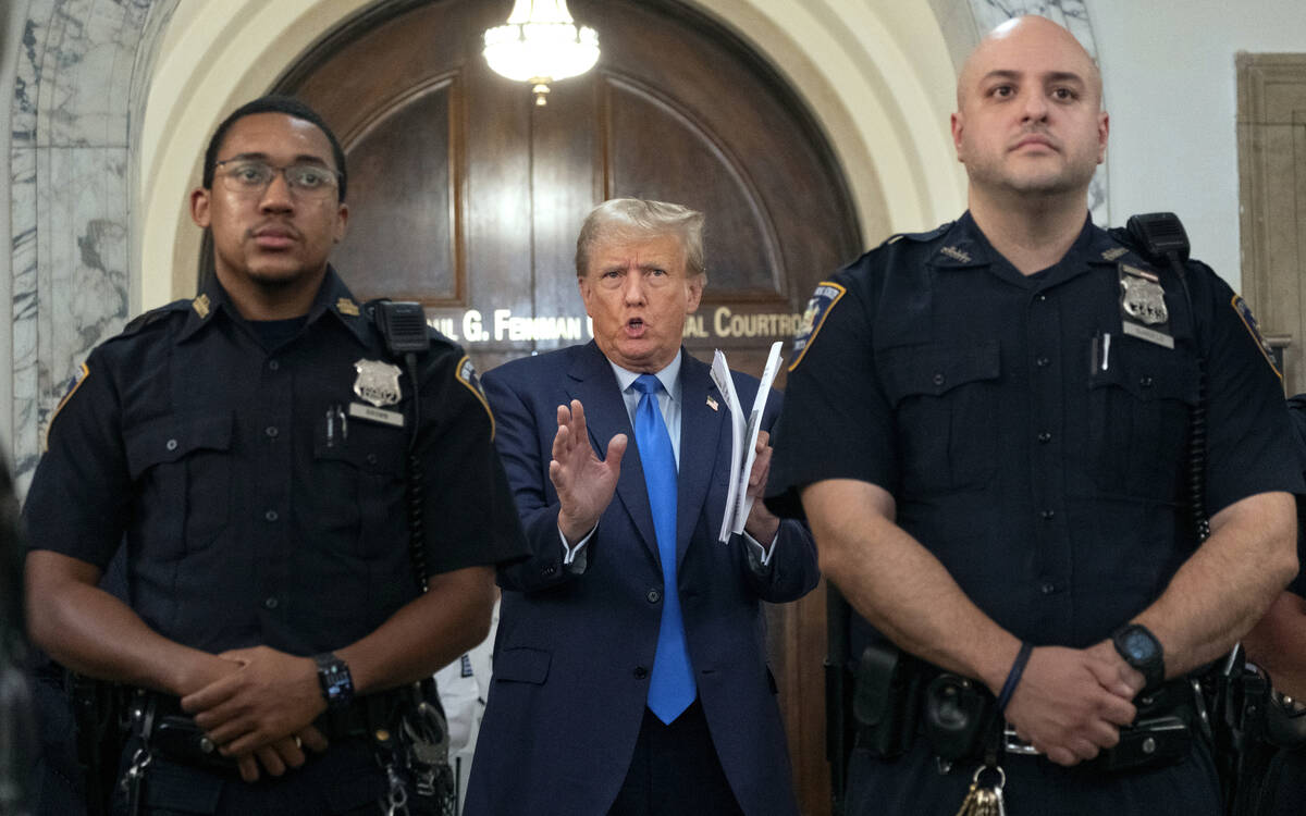 Former President Donald Trump speaks with journalists during a midday break from court proceedi ...