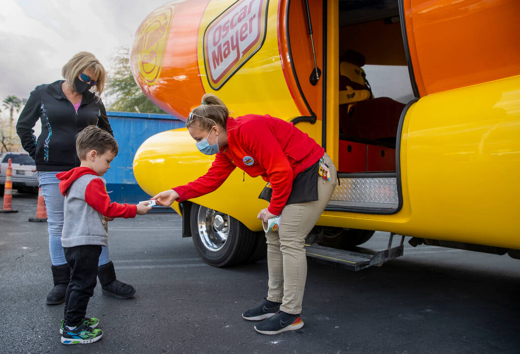 Niener Wiener, right, hands Brenden McCormack, 3, a sticker as he and aunt Corinne Weidman visi ...