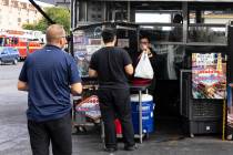 Customers wait in line to pick up their food from Casa del Sabor food truck at the corner of Bo ...