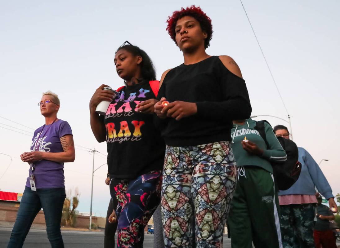 Haley Ramis, from right, Marva Smith, and Jody Rice-Wagner walk with candles during a vigil for ...