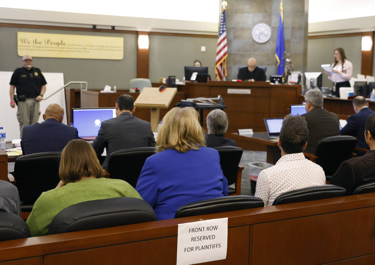 Plaintiffs, front row seated, listen as the court clerk, far right, reads the jury's verdict at ...