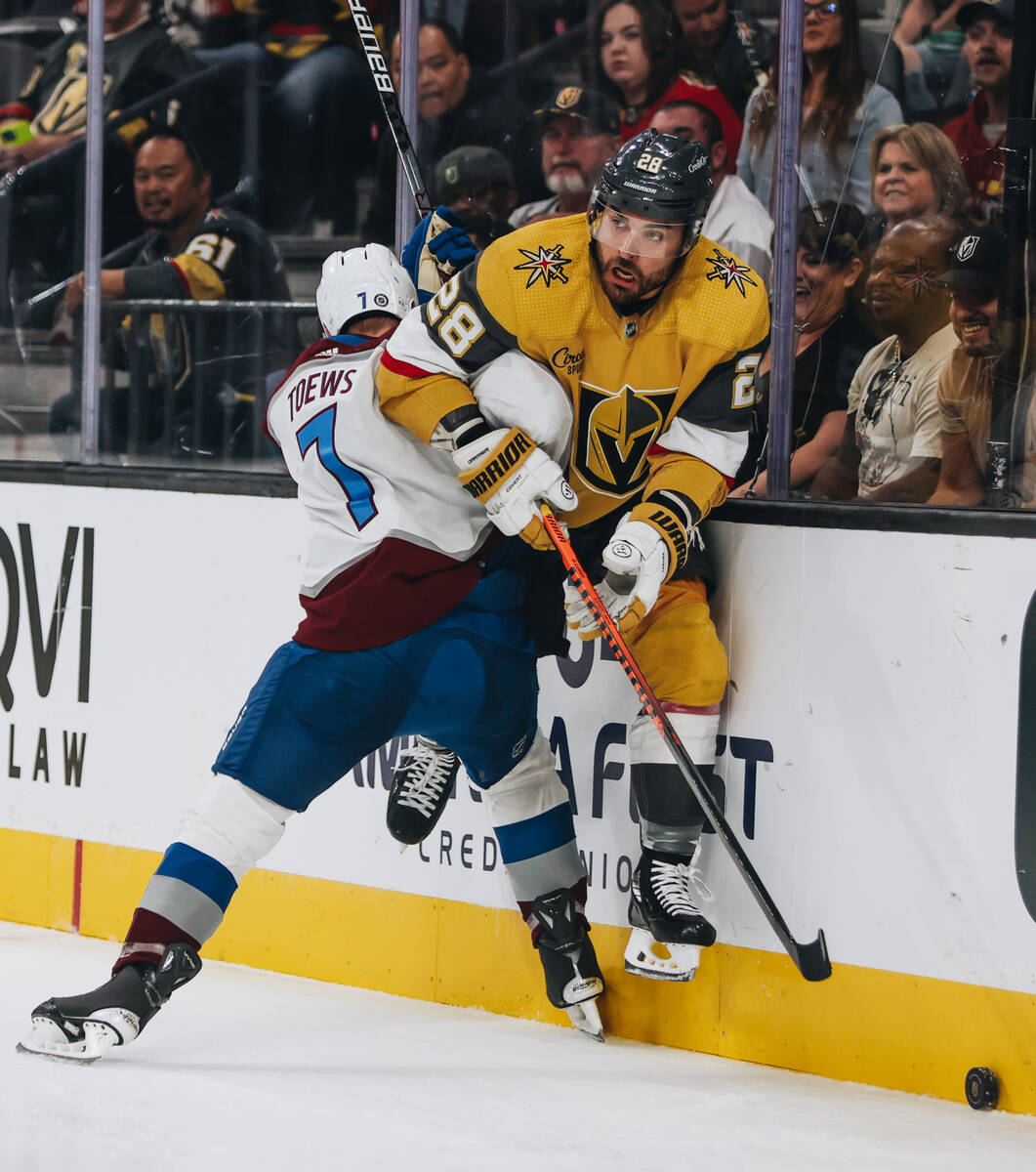 Golden Knights left wing William Carrier (28) is pushed against the glass by Colorado Avalanche ...