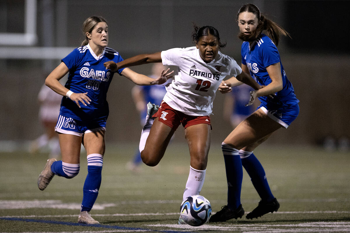 Liberty's Danica Key (12) drives between Bishop Gorman defender Tatum Manley (26) and defender ...