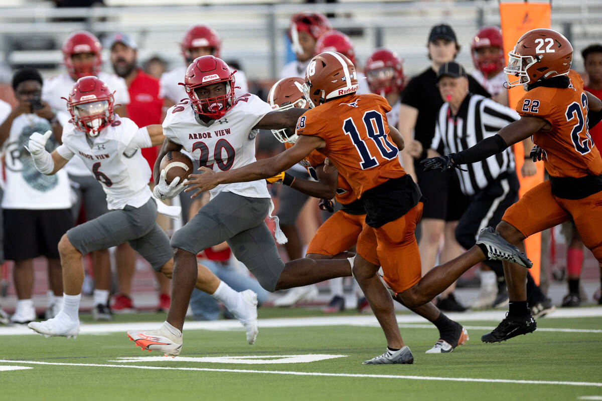 Arbor View running back Kamareion Bell (20) runs the ball while pushing away Legacy cornerback ...