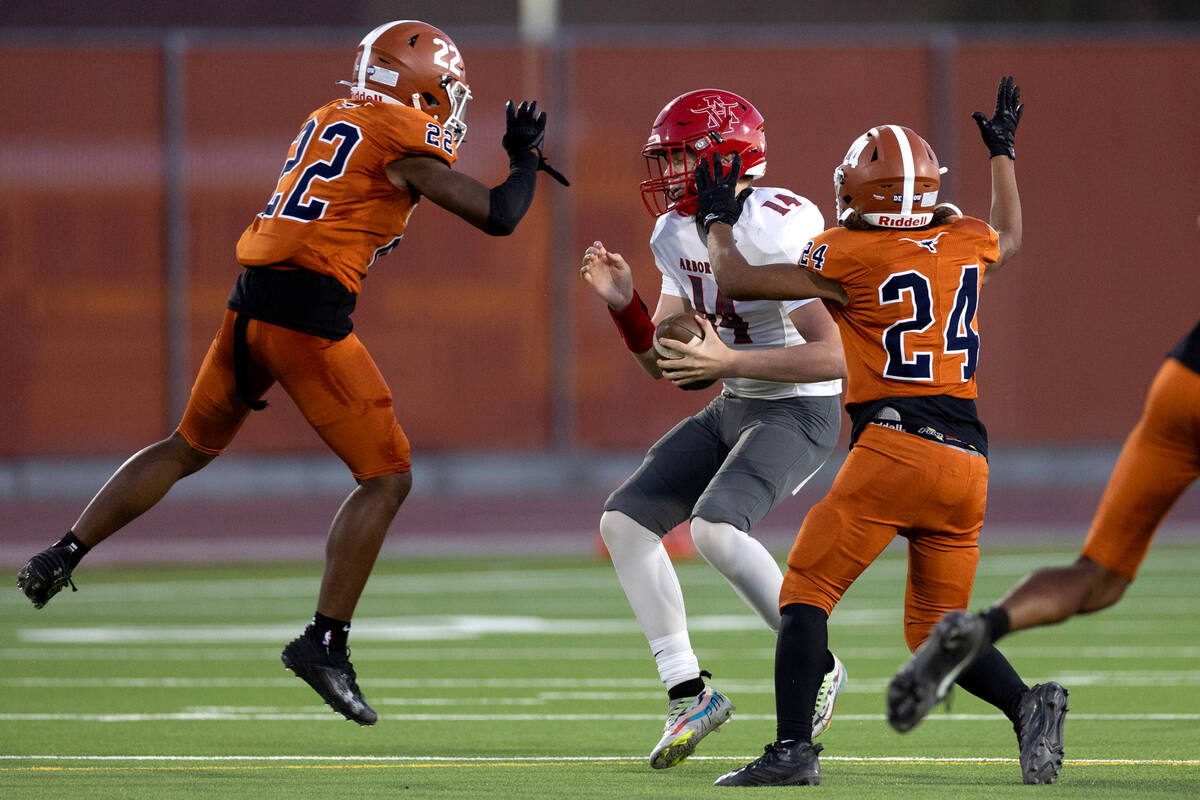 Legacy linebacker Martel McKenzie (22) and middle linebacker Anthony Hern (24) surround Arbor V ...