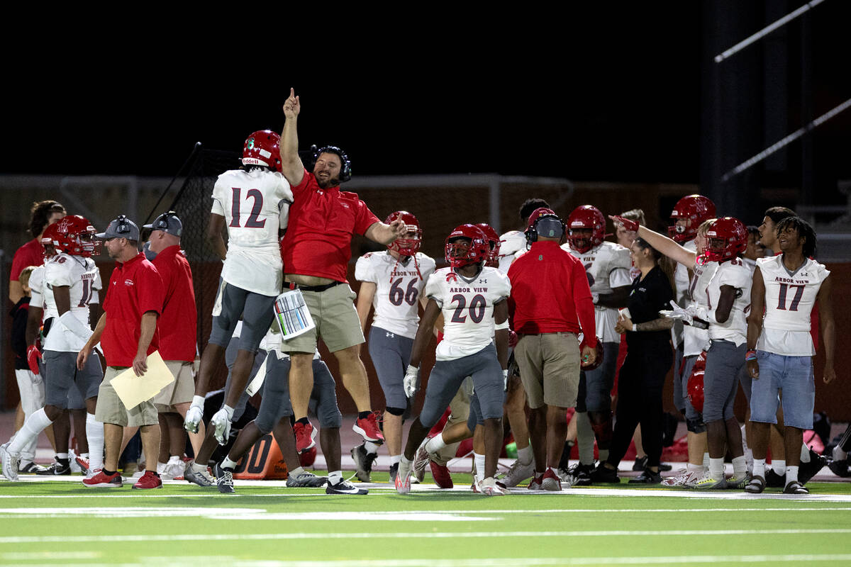 Arbor View wide receiver Damien Dixon Jr. (12) celebrates with head coach Matt Gerber after sco ...