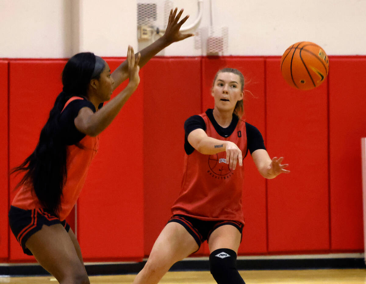 UNLV Lady Rebels Ashley Scoggin (0) passes the ball as forward Macie James (20) defends during ...