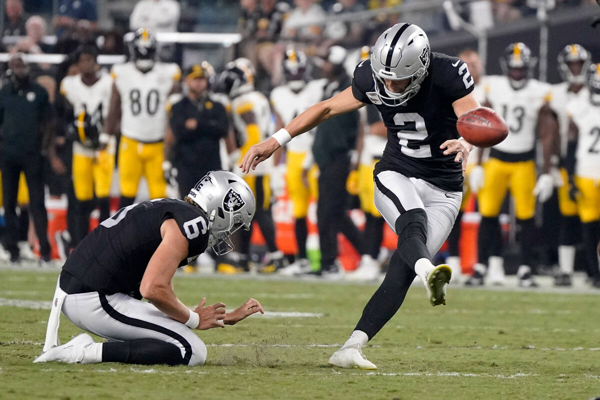 Las Vegas Raiders place kicker Daniel Carlson, top, kicks a field goal as punter AJ Cole holds ...