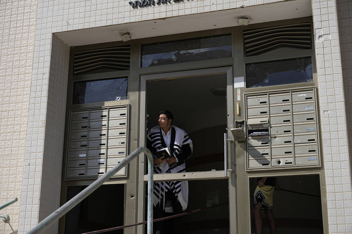An ultra-Orthodox Jew peers out of a building after a rocket attack from the Gaza Strip in Ashk ...