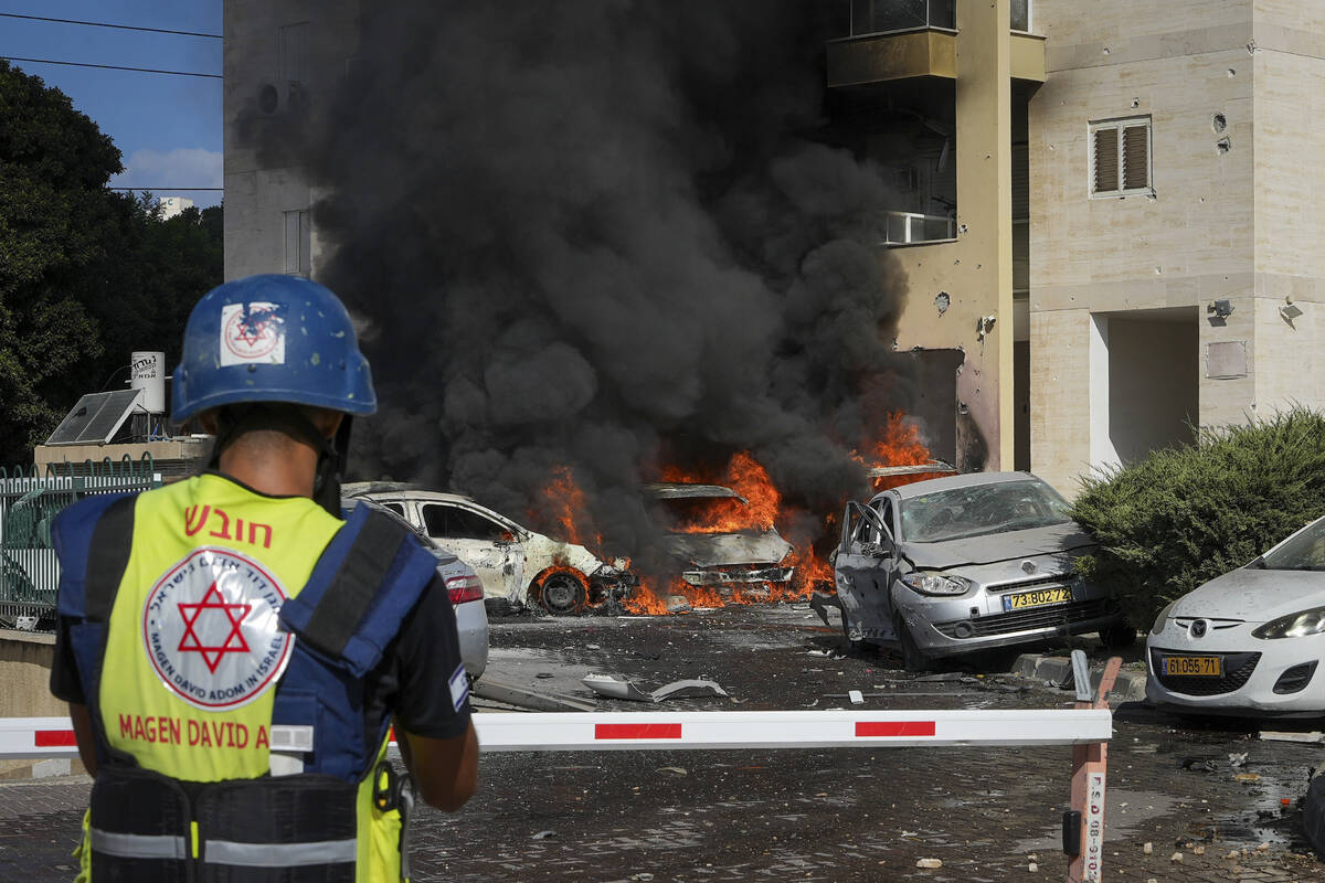 Cars burn after a rocket fired from the Gaza Strip hit a parking lot and a residential building ...