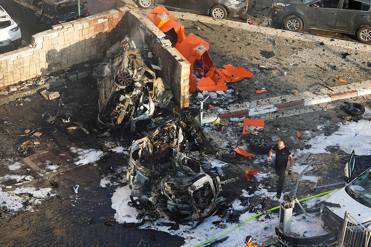 Israeli firefighters extinguish fire after a rocket fired from the Gaza Strip hit a parking lot ...