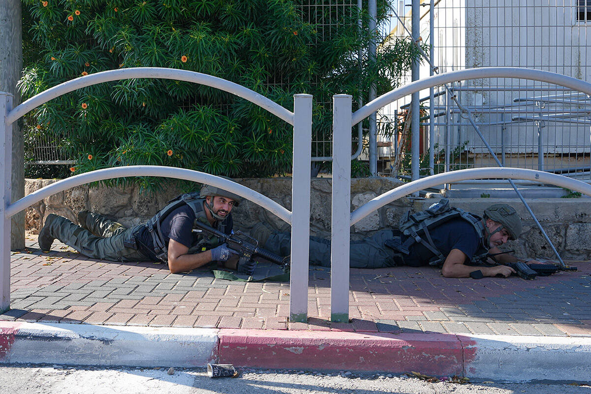 Israeli security forces take cover during rocket attack siren warning as rocket fired from the ...