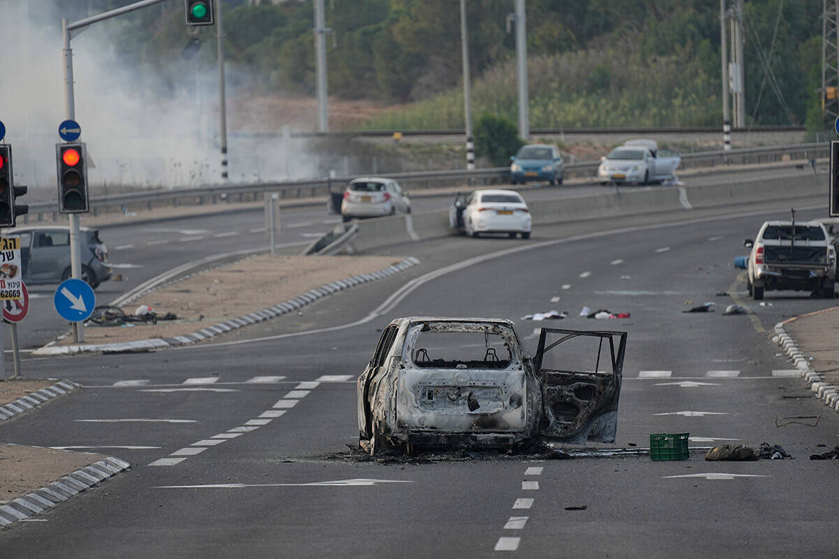 A car destroyed in an attack by Palestinian militants is seen in Sderot, Israel, on Saturday, O ...